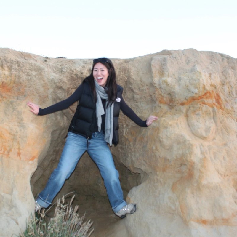 Jasmine laughing, stretched across a sandstone rock